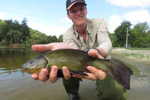 WFR1820.52Fish Game Officer Hamish Stevens displays a Centennial Park tench Credit R Adams